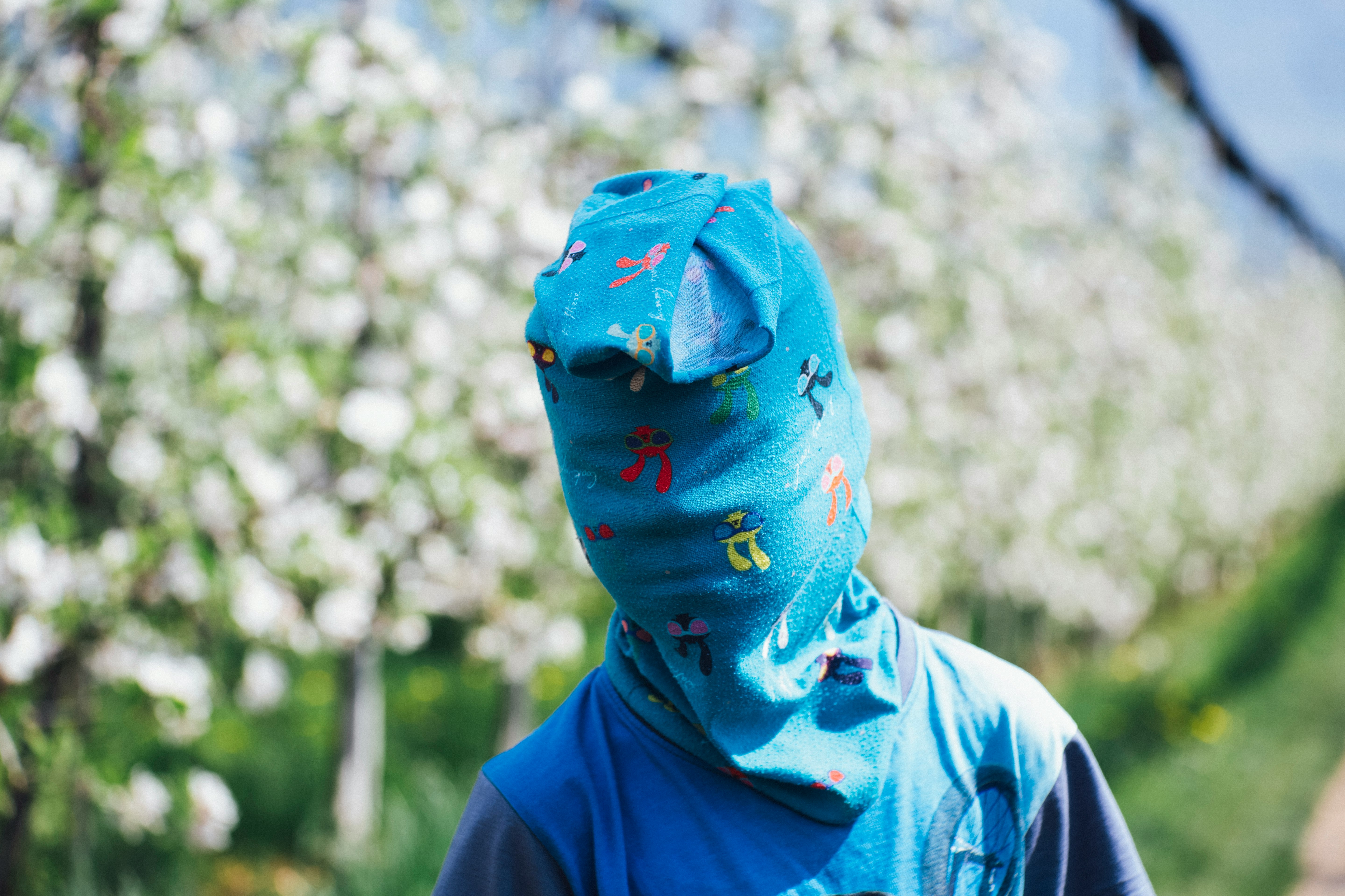 person in blue shirt with cover in face